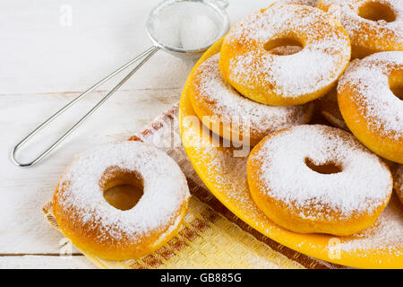 Homemade donuts powdered by caster sugar. Doughnuts. Sweet pastry. Donuts. Sweet dessert. Stock Photo