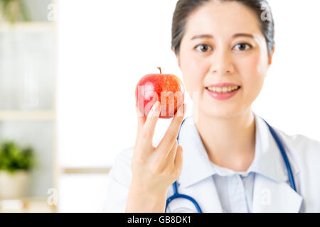 Young asian nutritionist holding an apple, healthy eating Stock Photo