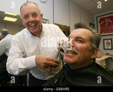 The SDLP's North Belfast councillor Alban Maginness MLA, has his moustache shaved off by barber David McGreevy (left) in aid of Children in Need in Belfast. Stock Photo