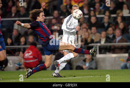 Real Madrid's David Beckham keeps his eye on the ball as he crosses under pressure from Barcelona's Carles Puyol Stock Photo