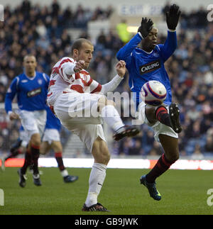 Hamilton's Trent McClenahan clears the ball under pressure from Rangers' DaMarcus Beasley (right) during the Clydesdale Bank Scottish Premier League match at Ibrox, Glasgow. Stock Photo