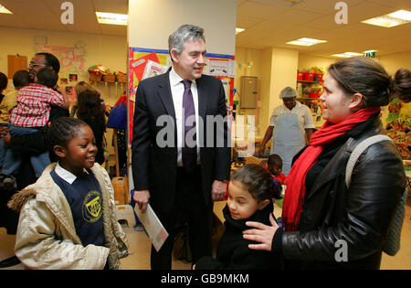 Prime Minister Gordon Brown chats with Claire Howe (right) and her two children during a visit to Westminster Children's Society in London, ahead of Labour Party's pre-budget report. Stock Photo