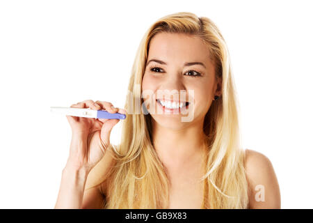 Excited young woman holding positive pregnancy test. Isolated on white. Stock Photo