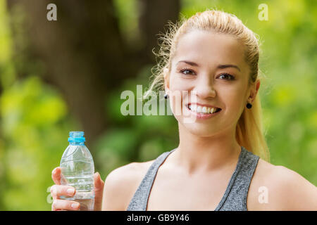 Sporty woman holding bottle of water. Stock Photo