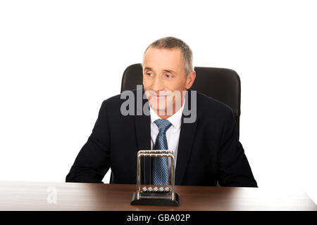 Businessman in the office with newton balls Stock Photo