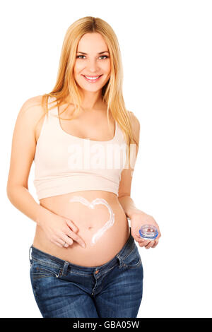 Pregnant woman applying cream on her belly Stock Photo