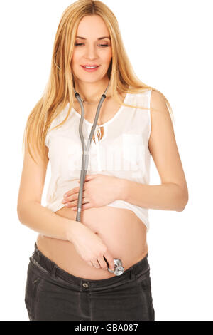 Pregnant woman with stethoscope listening her baby Stock Photo
