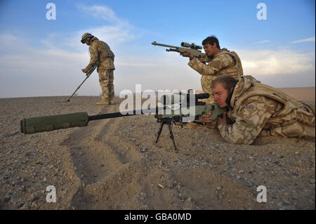 Snipers James Sudlow,22, from Owestry St. Martins, pictured right, and Corporal Dave Dale (area and age not given) from 1st The Queens Dragoon Guards train their scopes on the Nawar region of Helmand province as they watch and attempt to help locate enemy forces in a fire fight between the Taliban and the Afghan National Army while another soldier uses a Vallon mine detector to sweep the area so troops can safely move in by marking lines in the sand. Stock Photo