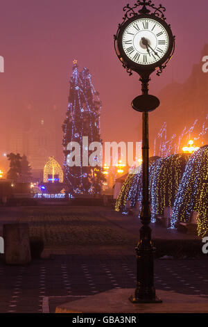 Modern clock in the center of the city. Moody fog in the night Stock Photo