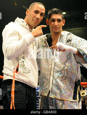 Great Britain's Amir Khan (right) is joined in the ring by former Olympic boxer and newly signed professional fighter James DeGale, following his second round victory over Ireland's Oisin fagan in the lightweight bout at the Excel Arena, London. Stock Photo