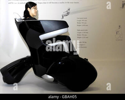 A girl sits in a Toyota i-REAL in the Science Museum in London. The three-wheeled personal mobility vehicle is part of a new exhibition called 'Japan Car', which aims to showcase the future of car transport. Stock Photo
