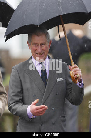 The Prince of Wales shelters from the rain under his umbrella outside the Thomas Hardye School in Dorchester, Dorset. Stock Photo