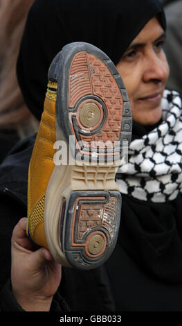 A woman waves a shoe in the air outside the American Embassy at Grosvenor Square, London, as part of a demonstration in support of Iraqi journalist Muntadar al-Zaidi, who was detained for throwing a shoe at US President George W Bush. Stock Photo