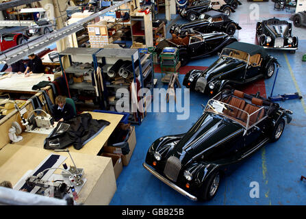 Cars wait in the finishing area as work is done on a soft top roof Stock Photo