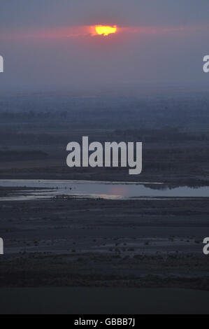 The sun sets near an area of fighting between the Taliban and the Afghan National Army in the Nawa region of Helmand Province. Stock Photo