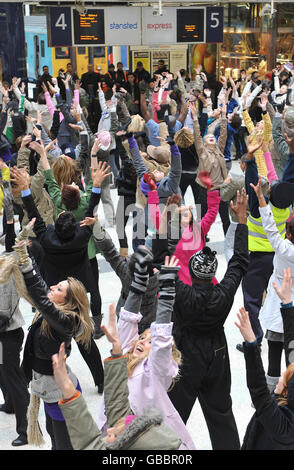 A huge crowd of dancers entertain commuters as they dance during the ...