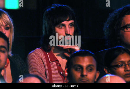 Serge Pizzorno of the pop group Kasabian looks on as Ronnie O'Sullivan plays a shot during The Masters Final at Wembley Arena, London. Stock Photo