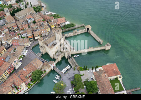 AERIAL VIEW. Medieval castle in a unique 'aquatic' setting on the shore of Lake Garda. Sirmione Peninsula, Province of Brescia, Lombardy, Italy. Stock Photo