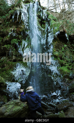 Walkers look at the Mallyan Spout waterfall in Goathland, North Yorkshire. Stock Photo