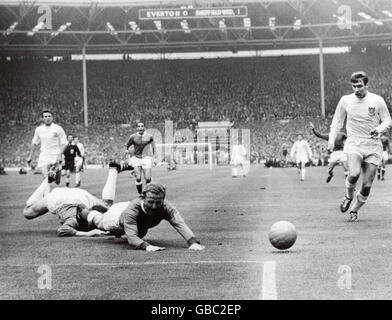 Everton's Alex Young (c) goes down in the penalty area under the challenge of Sheffield Wednesday goalkeeper Ron Springett (l), watched by Wednesday's Wilf Smith (r). No penalty was given Stock Photo