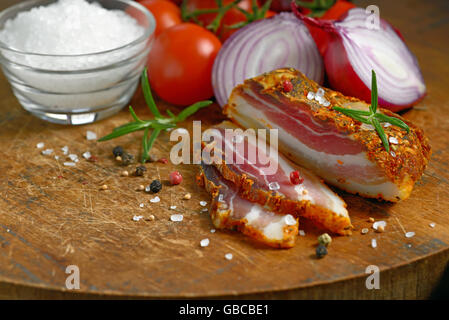 smoked bacon and vegetables on wooden table Stock Photo