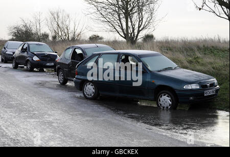 Damaged cars are left abandoned at the side of the road on Two Tree Island Nature Reserve, Leigh on Sea, Essex. Stock Photo