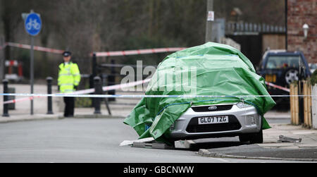 A police officer stands by a car covered by sheets where a man was shot dead in Formosa Road, Fazakerley, Liverpool last night. Stock Photo