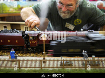 Model train driver, John Lovell from Leigh on Sea, Essex, adjusts his model train, The Duchess of Buccleugh, as it lets off steam at The London Model Engineering Exhibition in Alexandra Palace, north London. Stock Photo