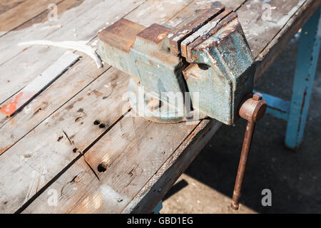 Old vice mounted on a workbench, closeup photo with selective focus Stock Photo