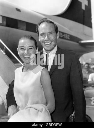 British actress Audrey Hepburn and her actor husband Mel Ferrer at London Airport on their arrival from Geneva for the premiere of Hepburn's new film 'The Nun's Story' at the Warner Theatre, London, and to take part afterwards in the 'Night of 100 Stars' show at the Palladium in aid of the Actors' Orphanage. Stock Photo