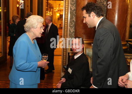 Britain's Queen Elizabeth II talks to Marcus Tripp (centre) from Sunshine Hospital Radio Weston-super-Mare and Matt Wade, from Hospital Radio Chelmsford, during a reception at Buckingham Palace in London, for people working in Healthcare in the UK. Stock Photo