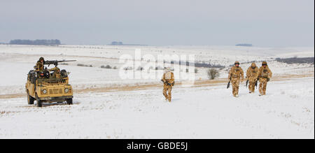 Members of the 1st Battalion The Welsh Guards (on foot) and The Black Watch, The 3rd Battalion The Royal Regiment of Scotland, rehearse their patrolling skills on a snow covered field at Westdown Camp on Salisbury Plain, Wiltshire. Stock Photo
