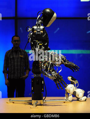 Berti the robot interacts with a Sony Aibo dog robot at the Science Museum in London. Stock Photo