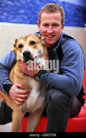 Former Royal Marine Penny Farthing with Bear, 1, a puppy who was rescued from dog fighting in Afghanistan, during his arrival to the Mayhew Animal Home in north west London. Stock Photo