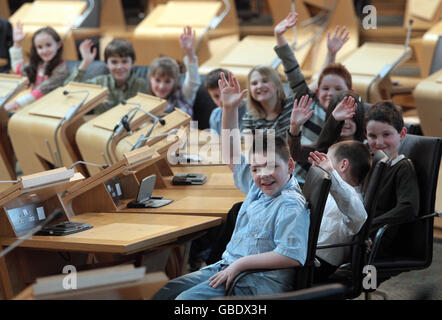 Front to back. Connor Moonie from Glasgow, William Pearson from Orkney, Charlie Dingwall from Pitlochry, Erinn McDonald from Carluke, Lawrence Callaghan from Hertfordshire, Sarah Duncan from Kircaldy, Ewan Carmichael from Kircaldy, Abigail Richardson from Edinburgh, Kieran Bell from East Lothian and Megan Manfredini from Ayrshire, all children born on July the 1st, gather in the Debating Chamber of the Scottish Parliament in Edinburgh, as part of parliament plans to mark 10 years of devolution. Stock Photo