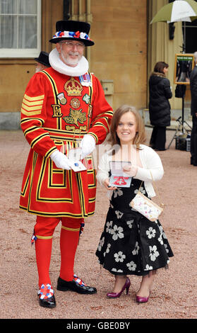 Yeoman Sergeant Roderick Truelove, who received a Royal Victorian Medal, stands with Paralympic swimmer Eleanor Simmonds after she received an MBE from Britain's Queen Elizabeth II at Buckingham Palace, London. Stock Photo