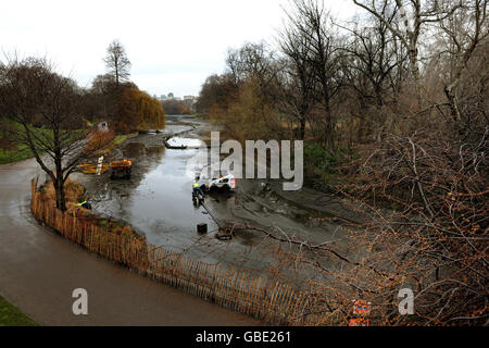 Workers check pipes at the bottom of the lake in St James' Park which is being drained for the first time since 1987. Stock Photo