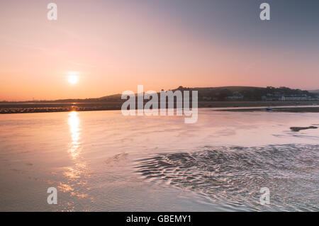 Sun rising over the water over the estuary leading to the ocean Stock Photo