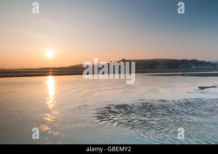 Sun rising over the water over the estuary leading to the ocean Stock Photo