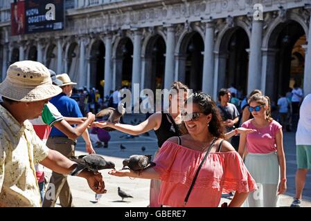 tourists, doves, feed, feeding, Piazza di San Marco, San Marco, square, Venice, Venezia, Veneto, Italy Stock Photo