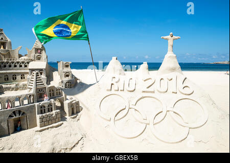 RIO DE JANEIRO - APRIL 4, 2016: Rio 2016 message made from sand topped by a model of Christ the Redeemer on Copacabana Beach. Stock Photo