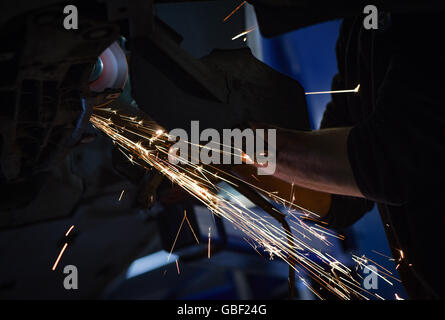 Mechanic working on car with cutter Stock Photo
