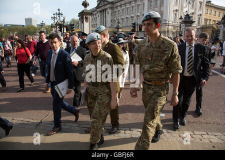 After a garden party at Buckingham Palace, military and civilian attendees happily leave after their royal experience in London, United Kingdom. Stock Photo
