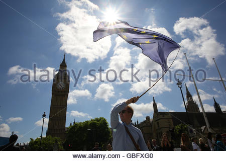 A man carries the EU flag past Big Ben in London on the day of the Brexit result. Stock Photo