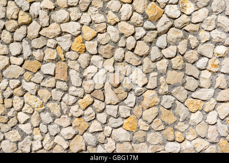 Natural stone wall of beige and yellow stones Stock Photo