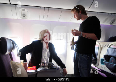 Sir Richard Branson talks to his son Sam during the first V Australia flight from Sydney, Australia to Los Angeles in the United States of America. Stock Photo