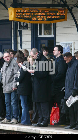 Commuters wait on the platform at Maidstone East Railway Station in Kent, after delays to train services following poor weather conditions. Stock Photo