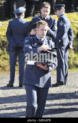 An RAF serviceman carries his colleagues hats as they carry out their pall bearing duties at the funeral of air cadet Katie-Jo Davies, 14, at St Barnabas Church, High Street, Gilfach Goch in South Wales. Stock Photo