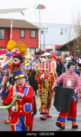 Members of Clowns International struggle against the wind and rain as they parade along the seafront in Bognor Regis, West Sussex,during the annual clowns parade in the town. Stock Photo