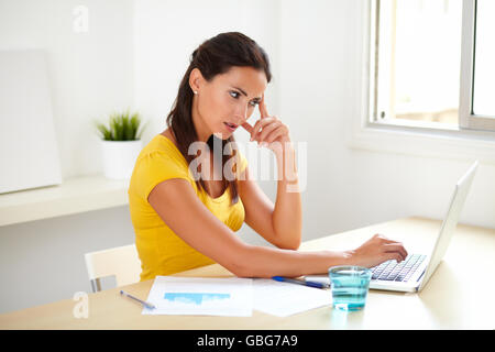Pensive businesswoman thinking while using the web at her office Stock Photo